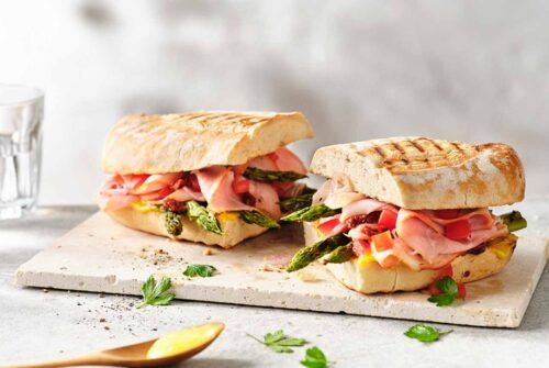 Ciabatta-Brot mit Aioli und Omaschinken, appetitlich angerichtet auf einem Brett.